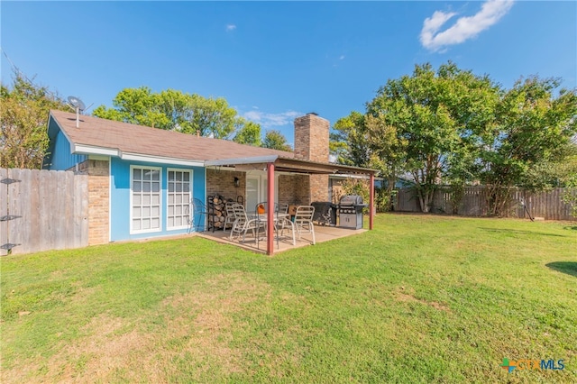 back of property with a patio and a yard