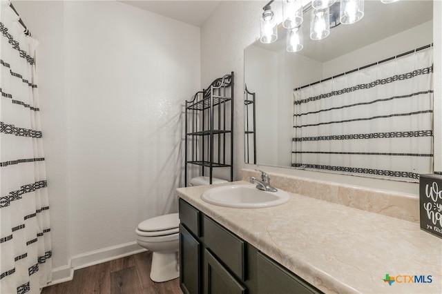 bathroom featuring toilet, vanity, and hardwood / wood-style flooring