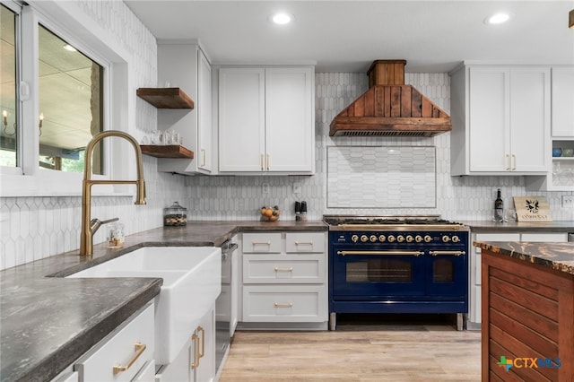 1910 S Rainbow Ranch Rd, Wimberley, TX 78676 - kitchen featuring range with two ovens, open shelves, custom exhaust hood, a sink, and backsplash
