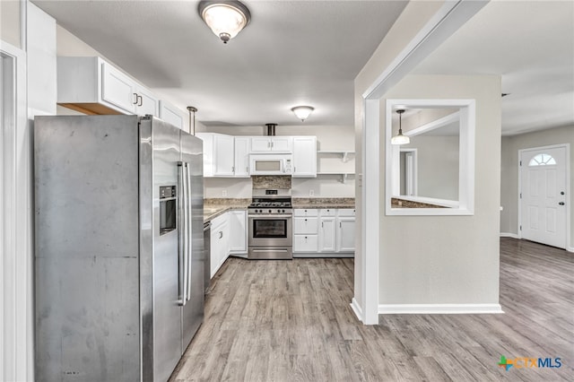 kitchen featuring stainless steel appliances, light hardwood / wood-style floors, white cabinets, and pendant lighting