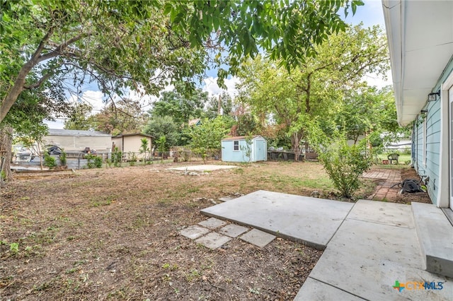 view of yard with a storage shed and a patio