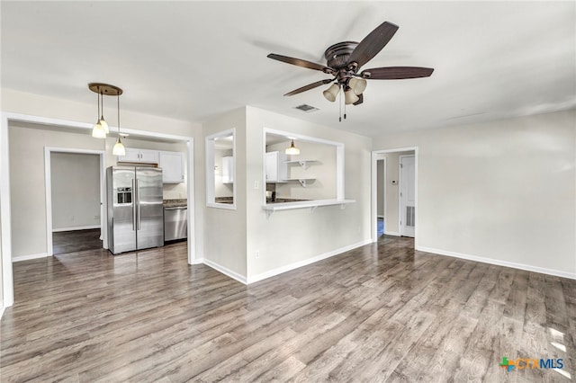 unfurnished living room with wood-type flooring and ceiling fan