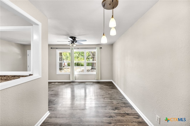 unfurnished living room featuring ceiling fan and dark hardwood / wood-style floors