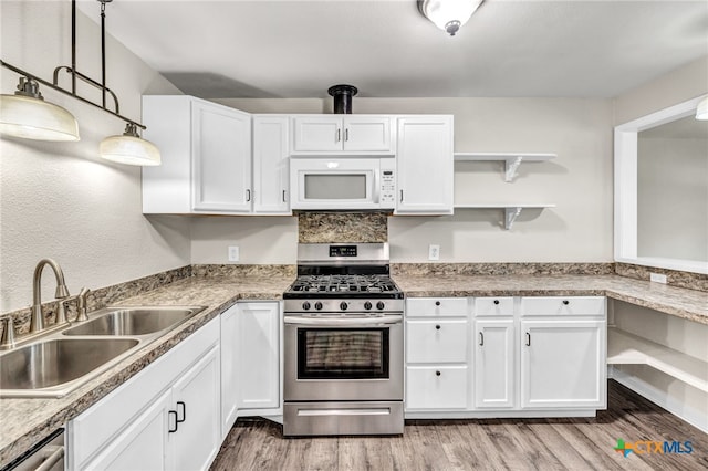 kitchen featuring hanging light fixtures, white cabinets, sink, and appliances with stainless steel finishes