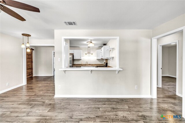 unfurnished living room with dark hardwood / wood-style flooring and ceiling fan