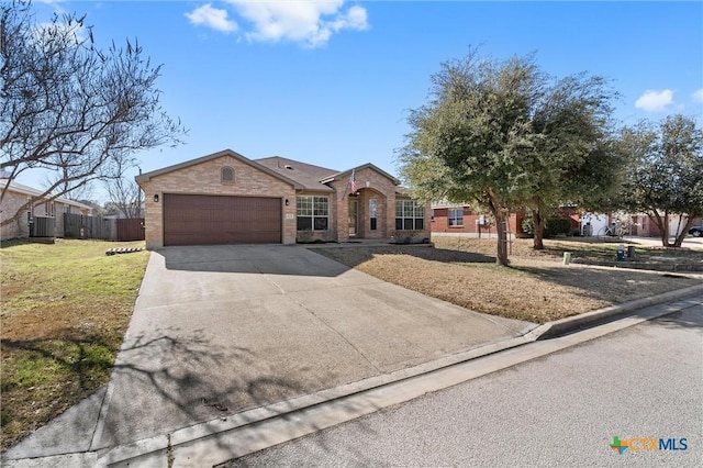 ranch-style home featuring brick siding, concrete driveway, a front yard, fence, and a garage