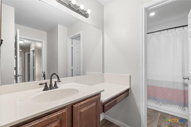 bathroom with a shower with shower curtain, wood finished floors, and vanity