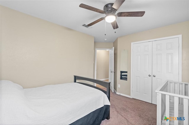 carpeted bedroom featuring ceiling fan, a closet, visible vents, and baseboards