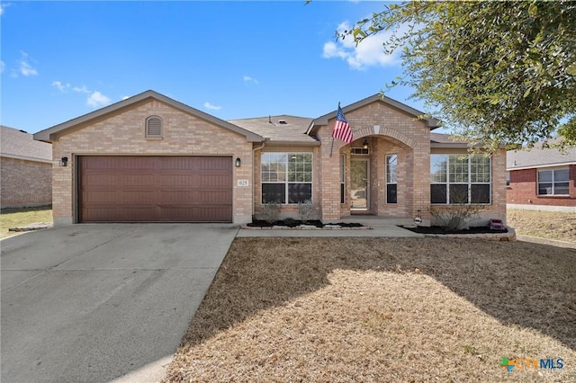 single story home featuring a garage, driveway, and brick siding