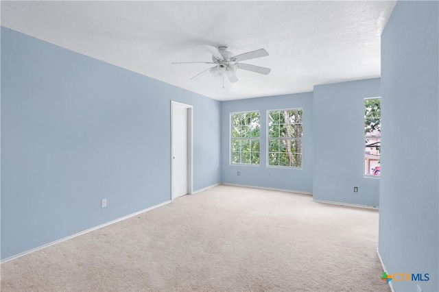 carpeted spare room with ceiling fan