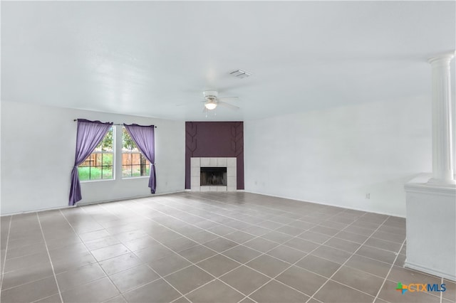 unfurnished living room with decorative columns, tile patterned flooring, ceiling fan, and a fireplace