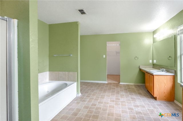 bathroom featuring a tub, vanity, and tile patterned floors