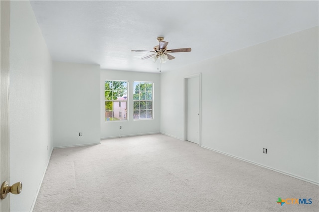 spare room with ceiling fan and light carpet