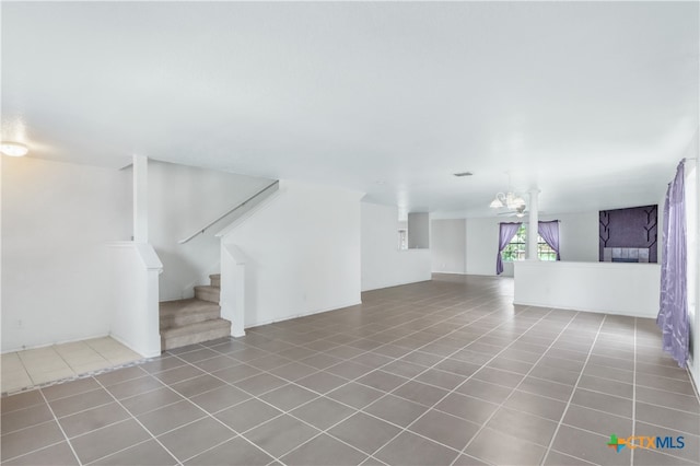 unfurnished living room featuring an inviting chandelier and tile patterned flooring