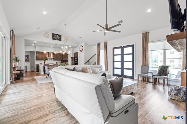 living room with high vaulted ceiling, light wood finished floors, visible vents, and recessed lighting