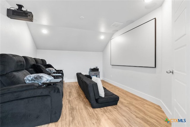 home theater room featuring baseboards, visible vents, vaulted ceiling, light wood-style floors, and recessed lighting