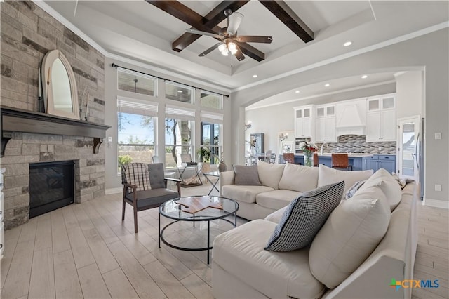1745 Alta Vista Loop, Temple, TX 76502 - living area with a ceiling fan, light wood finished floors, a stone fireplace, baseboards, and ornamental molding
