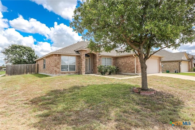 ranch-style home with brick siding, concrete driveway, an attached garage, fence, and a front lawn