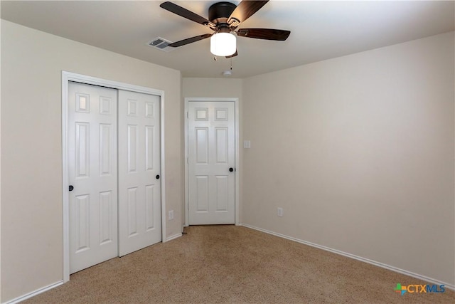 unfurnished bedroom featuring baseboards, visible vents, a closet, and light colored carpet