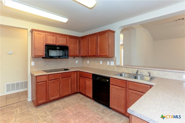 kitchen with a sink, visible vents, light countertops, decorative backsplash, and black appliances