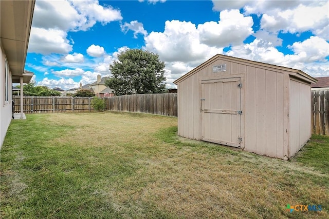 view of yard with a fenced backyard, a storage unit, and an outdoor structure