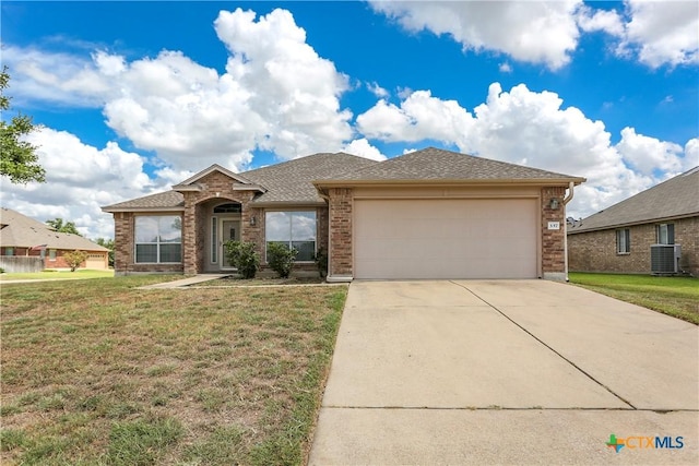 view of front of home with central AC unit, concrete driveway, an attached garage, a front lawn, and brick siding