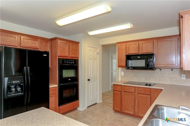 kitchen featuring black appliances, backsplash, a sink, and light countertops