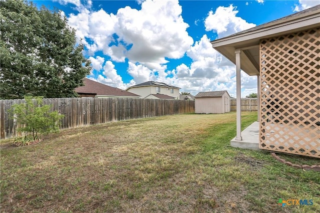 view of yard with a fenced backyard, a shed, and an outdoor structure