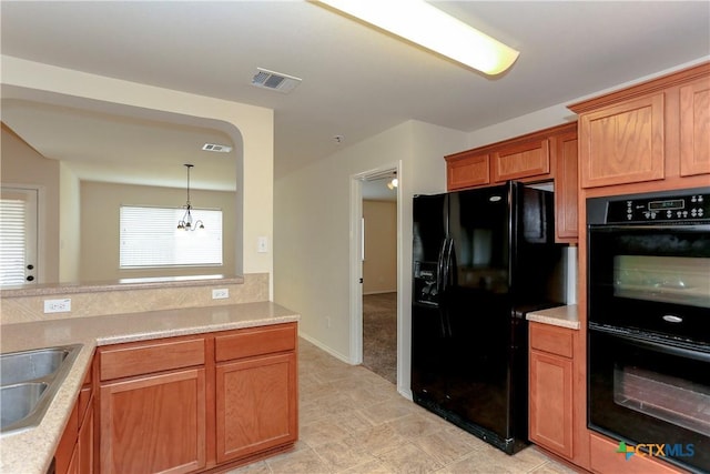 kitchen with light countertops, visible vents, a sink, and black appliances