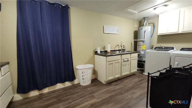 washroom featuring cabinets, dark hardwood / wood-style flooring, sink, washer and dryer, and water heater