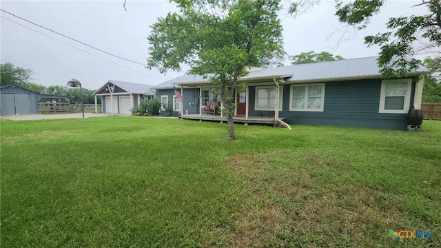 view of front of property with a front yard, an outbuilding, and a garage