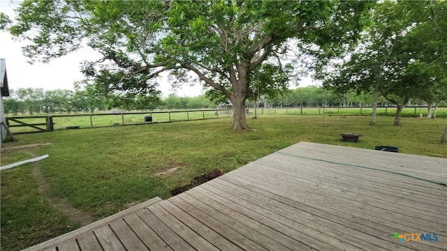 wooden deck featuring a rural view and a yard