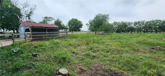 view of yard with a rural view and an outdoor structure