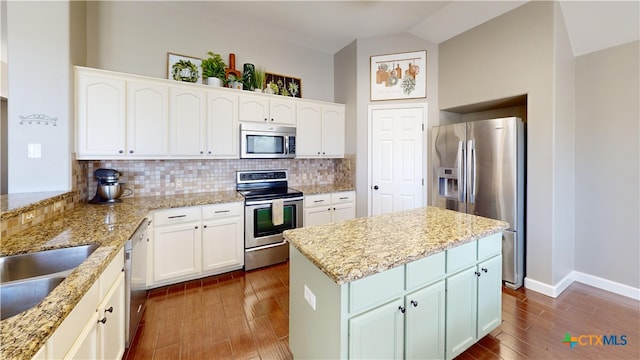 101 Arabian Dr, Victoria, TX 77904 - kitchen with appliances with stainless steel finishes, tasteful backsplash, dark wood-type flooring, a center island, and vaulted ceiling