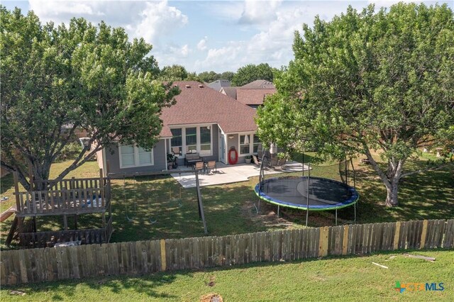 101 Arabian Dr, Victoria, TX 77904 - back of property featuring a trampoline, a patio area, and roof with shingles