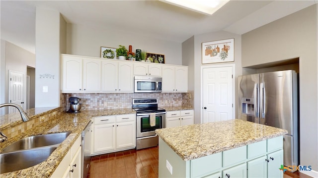 101 Arabian Dr, Victoria, TX 77904 - kitchen with stainless steel appliances, lofted ceiling, decorative backsplash, white cabinets, and dark wood-style flooring