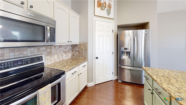 101 Arabian Dr, Victoria, TX 77904 - kitchen featuring stainless steel appliances, tasteful backsplash, dark wood-style floors, and white cabinetry