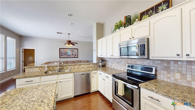 101 Arabian Dr, Victoria, TX 77904 - kitchen featuring appliances with stainless steel finishes, dark wood-style flooring, a peninsula, and decorative backsplash