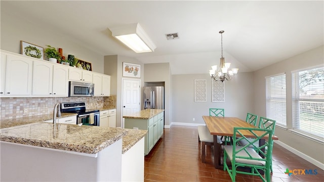 101 Arabian Dr, Victoria, TX 77904 - kitchen with appliances with stainless steel finishes, a chandelier, tasteful backsplash, a kitchen island, and lofted ceiling