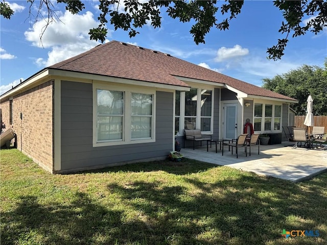 101 Arabian Dr, Victoria, TX 77904 - back of property featuring a shingled roof, a patio area, and brick siding
