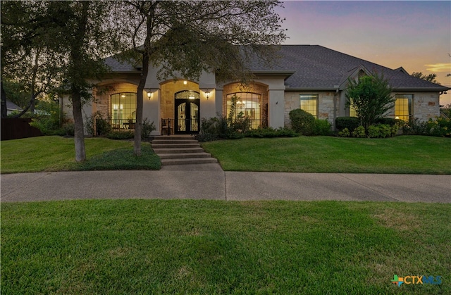 view of front facade featuring french doors and a yard