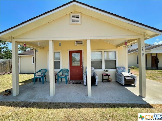 rear view of property featuring a patio and a yard