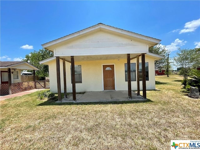 back of property with a patio and a lawn