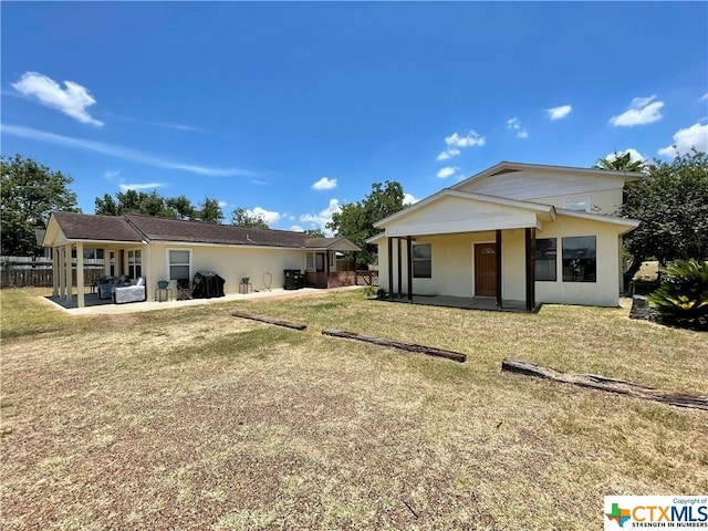 back of property with a patio and a lawn