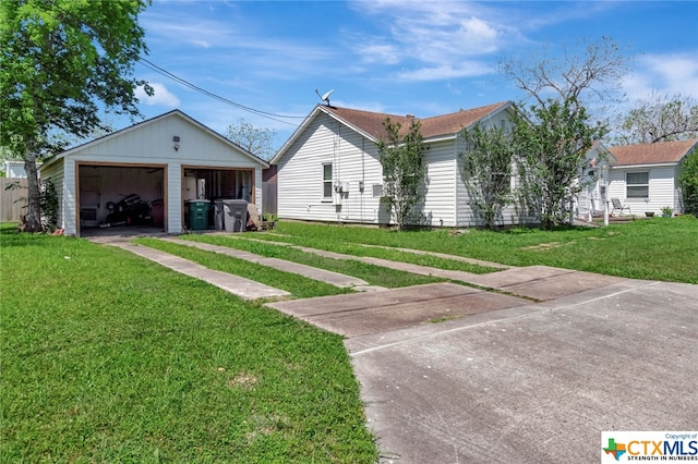 view of front of house featuring a garage, an outdoor structure, and a front lawn