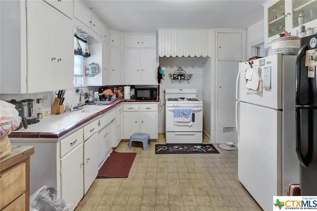 kitchen featuring white cabinets, white appliances, tile countertops, and sink