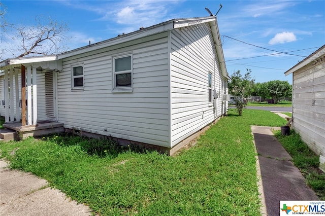 view of side of home with a yard