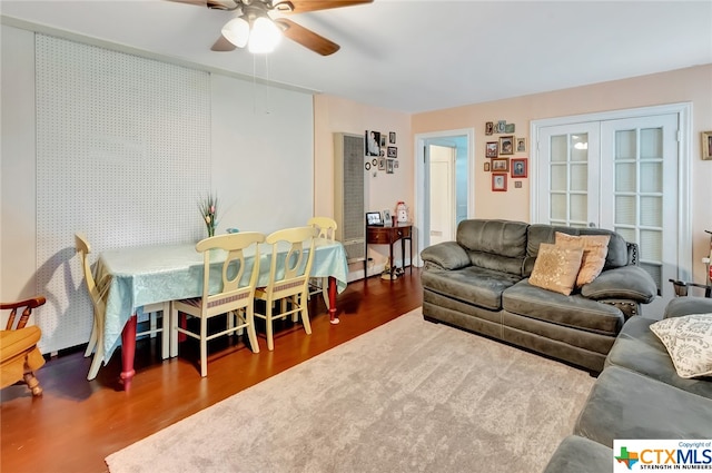 living room featuring ceiling fan and dark hardwood / wood-style floors