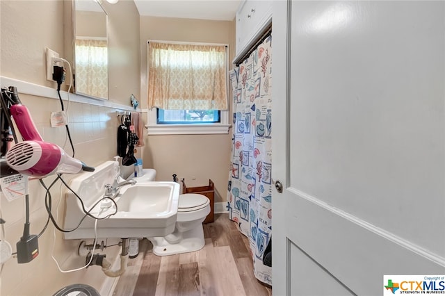 bathroom featuring toilet, backsplash, and hardwood / wood-style flooring