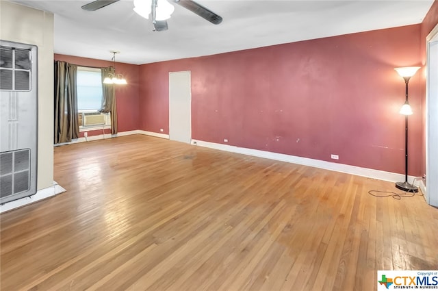 unfurnished living room featuring hardwood / wood-style floors and ceiling fan with notable chandelier